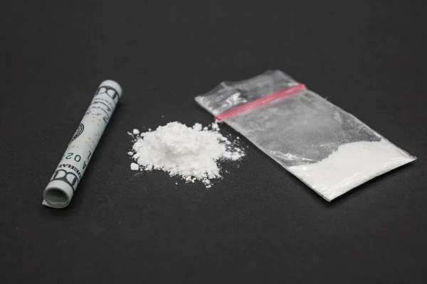 Dökülmüş beyaz toz. Uyuşturucu bağımlılığı. Bir tüp içinde yüz dolar, bir paket uyuşturucu..