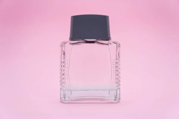 Perfume glass bottle. Perfume bottle with blank label on pink background.