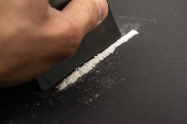 Beyaz çizgi ve plastik kart ellerinde..