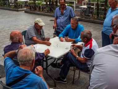 ACITREZZZA, ITALY, CIRCA AĞUSTOS 2021 Yaşlı emekliler, Covid-19 nedeniyle sokağa çıkma yasağından sonra kart oynuyorlar