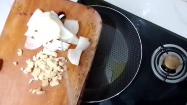 Soğan ve sarımsak tavada kızartılır. Kızarmış tavada doğranmış soğan. Soğan parçalarını tavaya döküyorum. Yukarıdan bakıldığında.