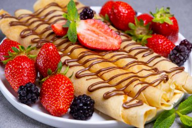 Taze çilek, çilek ve çikolatalı bir tabak lezzetli krep ya da krep. Üst manzara, düz yatış. Yüksek kalite fotoğraf