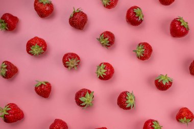 Pembe arka planda olgun çilekler, modaya uygun, parlak, yaz arkaplanı. 