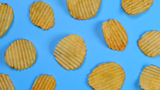 Roterande Blå Bakgrund Med Wellpapp Rufflad Potatis Chips — Stockvideo