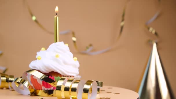 Tort Urodzinowy Lub Babeczka Płonącą Złotą Świecą Beżowym Tle Koncepcja — Wideo stockowe