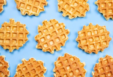 Mavi arka planda iştah açıcı tatlı waffle 'ların arka planı. Yaz, aydınlık, modaya uygun arka plan, gıda tasarımı. 