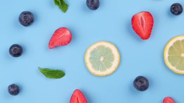 Fondo Giratorio Arándanos Fresas Rodajas Limón Hojas Menta Sobre Fondo — Vídeos de Stock