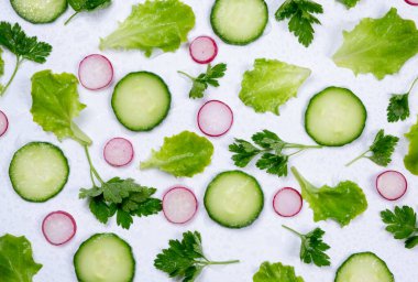 Marul yaprakları, salatalık dilimleri, turplar ve maydanoz yapraklarının dönüşümlü sebze arkaplanı. 