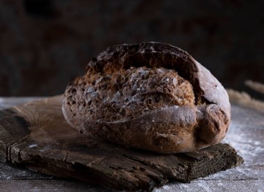 Ahşap arka planda taze siyah ekmek. Gösterişsiz yaşam konsepti geleneksel fırın. Kırsal kesim. Yüksek kalite fotoğraf