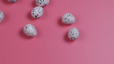 Paskalya yumurtaları pembe arka planda yuvarlanır. Paskalya kutlaması konsepti. Yüksek kalite 4k görüntü