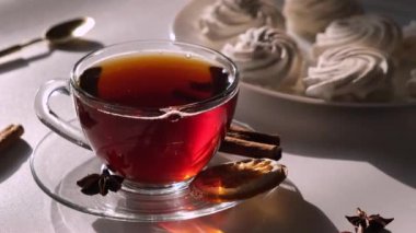 Şeffaf fincanda çay ya da fincanda beyaz, açık arkaplanda kremalı pasta, şekerli kahvaltı ya da sabah konsepti. Yüksek kalite 4k görüntü