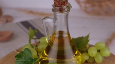 Ahşap bir arka planda yeşil üzümlere karşı üzüm yağıyla dönen sürahi ya da şişe ya da üzüm yağı ile ahşap bir zeminde yeşil üzümlere karşı olan üzüm yağı. Yüksek kalite 4k görüntü