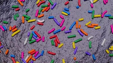 Tatlı ve çok renkli sürahiler ya da tatlılar için çok renkli serpintilerin dönüşümlü arka planı. Doğum günü, parti ya da diğer bayramları kutlama konsepti. Moda, tatlı arka plan.