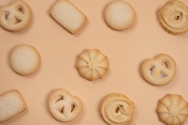 Bej ya da şeftali arkaplanındaki kurabiyelerin arkaplanı, pastel renklerdeki gıda modası. 