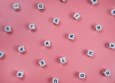  Pembe arka planda rastgele harflerle kelime küpleri ya da bloklar - yeni doğmuş bir kız, okul eğitimi ya da öz eğitim kavramı .