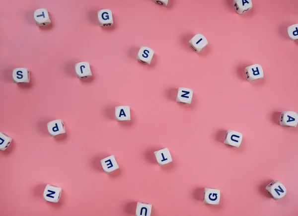  Pembe arka planda rastgele harflerle kelime küpleri ya da bloklar - yeni doğmuş bir kız, okul eğitimi ya da öz eğitim kavramı .