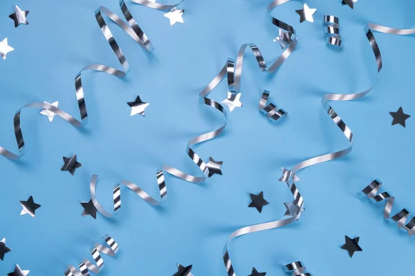 Beyaz arka planda gümüş bir yılanbalığı ve yıldızlar, gümüş tonlarda bir doğum günü, parti ya da yıldönümü konsepti.. 