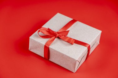  Kırmızı kurdeleli hediye kutusu ve kırmızı arka planda fiyonk. Sevgililer günü ya da sevgililer günü ya da doğum günü kavramı. 