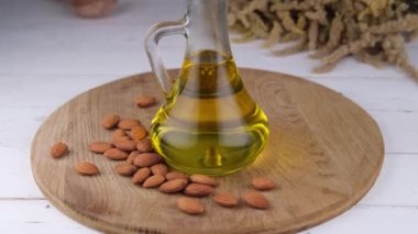 Tahta bir arka planda badem yağı ve badem fıstığı olan sürahi ya da şişe. Yüksek kalite 4k görüntü