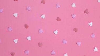 Pembe arka plandaki kalplerin dönüşümlü arkaplanı. Aşk konsepti ya da parti, yıldönümü, sevgililer günü, pembe renkler. Yüksek kalite 4k görüntü