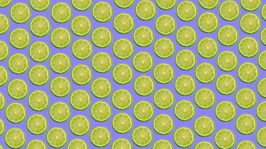 Colorful pattern of ripe lime slices on a purple and lilac background. High quality photo