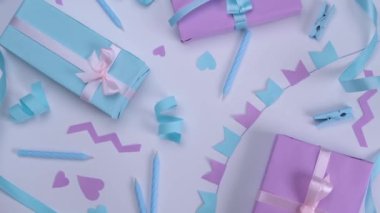 Rotating white background with candles, gift boxes, serpentine and holiday decorations in blue and lilac colors for birthday or party celebration, birthday, anniversary, congratulations concept. High
