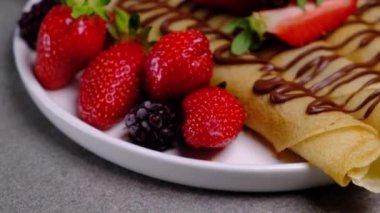 Çikolatalı, çilekli ve böğürtlenli krep ruloları. Yüksek kalite 4k görüntü