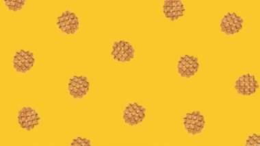 animation of rotating waffles on a yellow background. High quality 4k footage