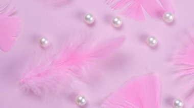 Pembe arka planda pembe tüyler, inci kolyeler, modaya uygun, dekoratif, narin, kadınsı bir arka plan. Parti konsepti ya da pembe renkli doğum günü konsepti ya da yeni doğmuş bir kız. Yüksek kalite 4k