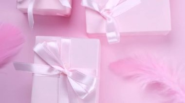 Pembe fiyonklu pembe hediye kutularıyla donatılmış arka plan tüylerle süslenmiş, üst görünüm, kızların doğum günü, parti, pembe renkli yıldönümü ya da satış konsepti.