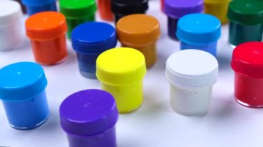 Beyaz arka planda çok renkli boyalar olan bir sürü kavanoz, sanat eğitimi, yaratıcılık ve sanat konsepti. Yüksek kalite 4k görüntü