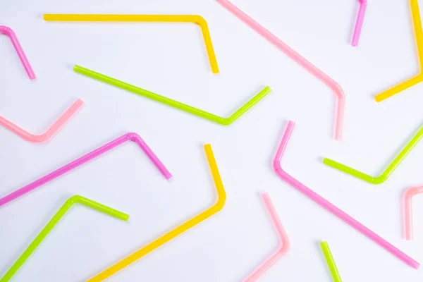 Beyaz arka planda çok renkli kokteyl pipetleri, üst görünüm, doğum günü, parti veya yıldönümü konsepti. 