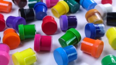 Beyaz arka planda çok renkli boyalar bulunan bir sürü kavanoz, sanat eğitimi, yaratıcılık ve sanat kavramı.