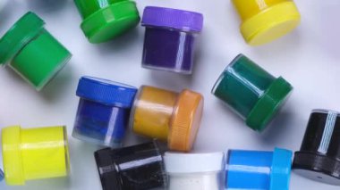 Beyaz arka planda çok renkli boyalar bulunan bir sürü kavanoz, sanat eğitimi, yaratıcılık ve sanat kavramı.