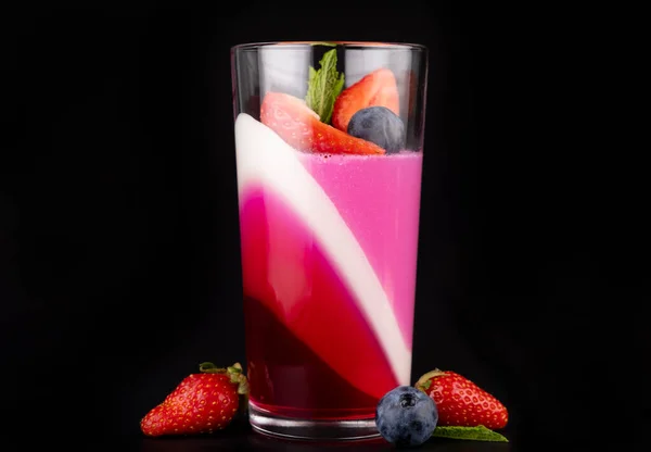 Siyah arka planda çilekli ve yaban mersinli meyveli jöle, güzel bir tatlı..