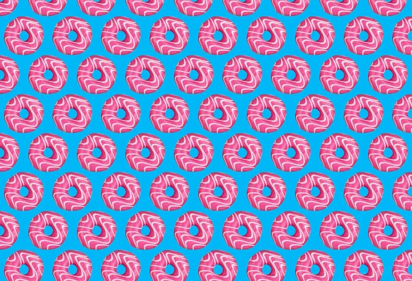 Modern moda yemekler, mavi arka planda pembe çöreklerin tekrarlanan desenleri. Yemek kolajı. Yüksek kalite fotoğraf