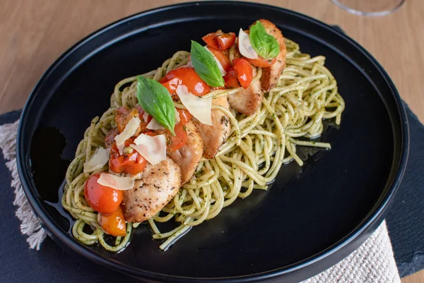 Siyah tabakta tavuk makarnalı vişneli domates. Yüksek kalite fotoğraf