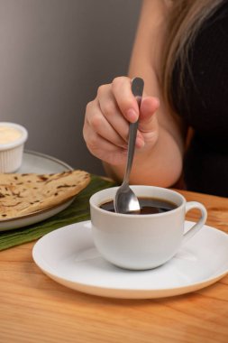 Tahta bir masada kaşıkla beyaz bir fincan kahve. Yüksek kalite fotoğraf