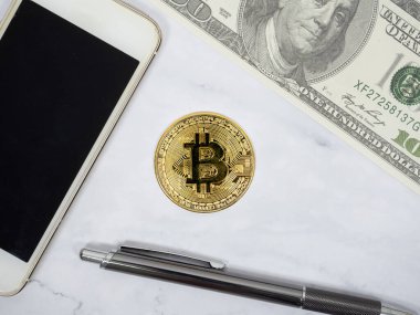 Telefon, dolar ve kalem manzaralı altın bitcoin.