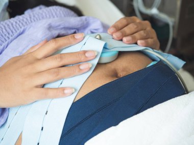 Hastanedeki tıbbi malzemelerle bebeği kontrol etmek için yatağa odaklan.