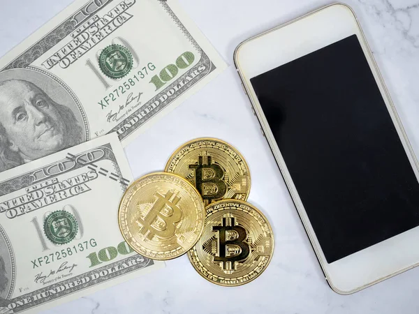 Yakın plan Altın Bitcoin telefon ve dolar ve kalem üst görünüm kripto para konsepti