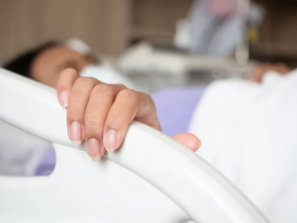 Closeup hand of woman sick lay at hospital holding at rail bed