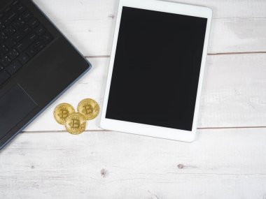 Tablet ve dizüstü bilgisayarı olan bitcoin 'ler ahşap masa görünümünde