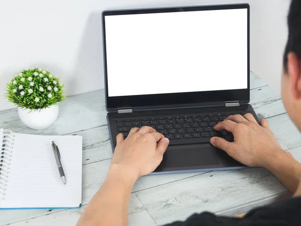 Back view of man working on laptop white screen on the desk workspace and work at home concept