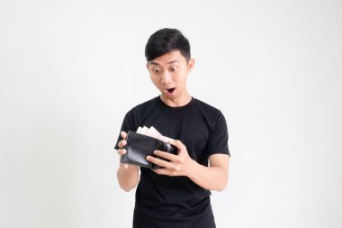 Genç adam siyah gömlek şoku ve cüzdanındaki paraya bak. Mutlu yüz ifadesi, izole edilmiş beyaz adam konsepti.