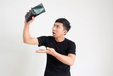 Siyah gömlekli genç adam, elinde cüzdanı tutuyordu. Şok yüzlü parayı bulmak için. Beyazların izole edilmiş, zavallı adam konseptinde mutsuz.