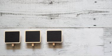 Beyaz ahşap masa üzerinde üç küçük klip tahta çerçeve dizisi uzayın üzerindeki doğa gölgesi, fikir tabelaları konsepti