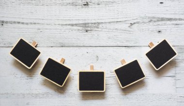 Beyaz ahşap masa üzerinde beş küçük klip karatahta eğrisi dizisi boşluk altında doğa gölgesi, fikir tabelaları konsepti