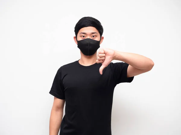 Portrait man wearing mask show thumb down disagree looking at camera white background