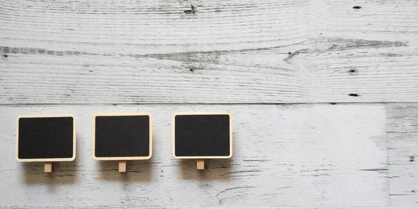 Beyaz ahşap masa üzerinde üç küçük klip tahta çerçeve dizisi uzayın üzerindeki doğa gölgesi, fikir tabelaları konsepti